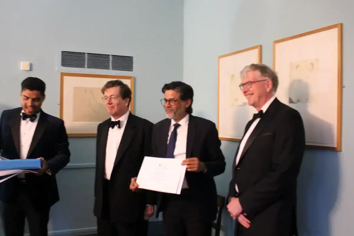 A participant receiving a certificate from Oxford faculty