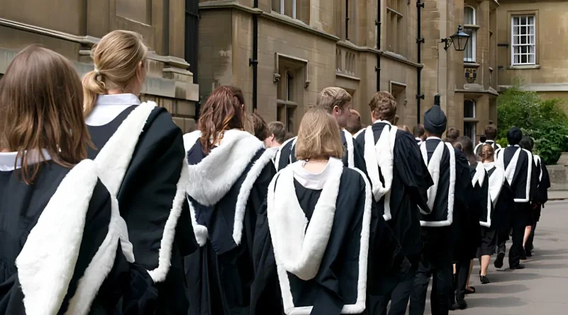 Graduates in gowns walking past college buildings in Oxford